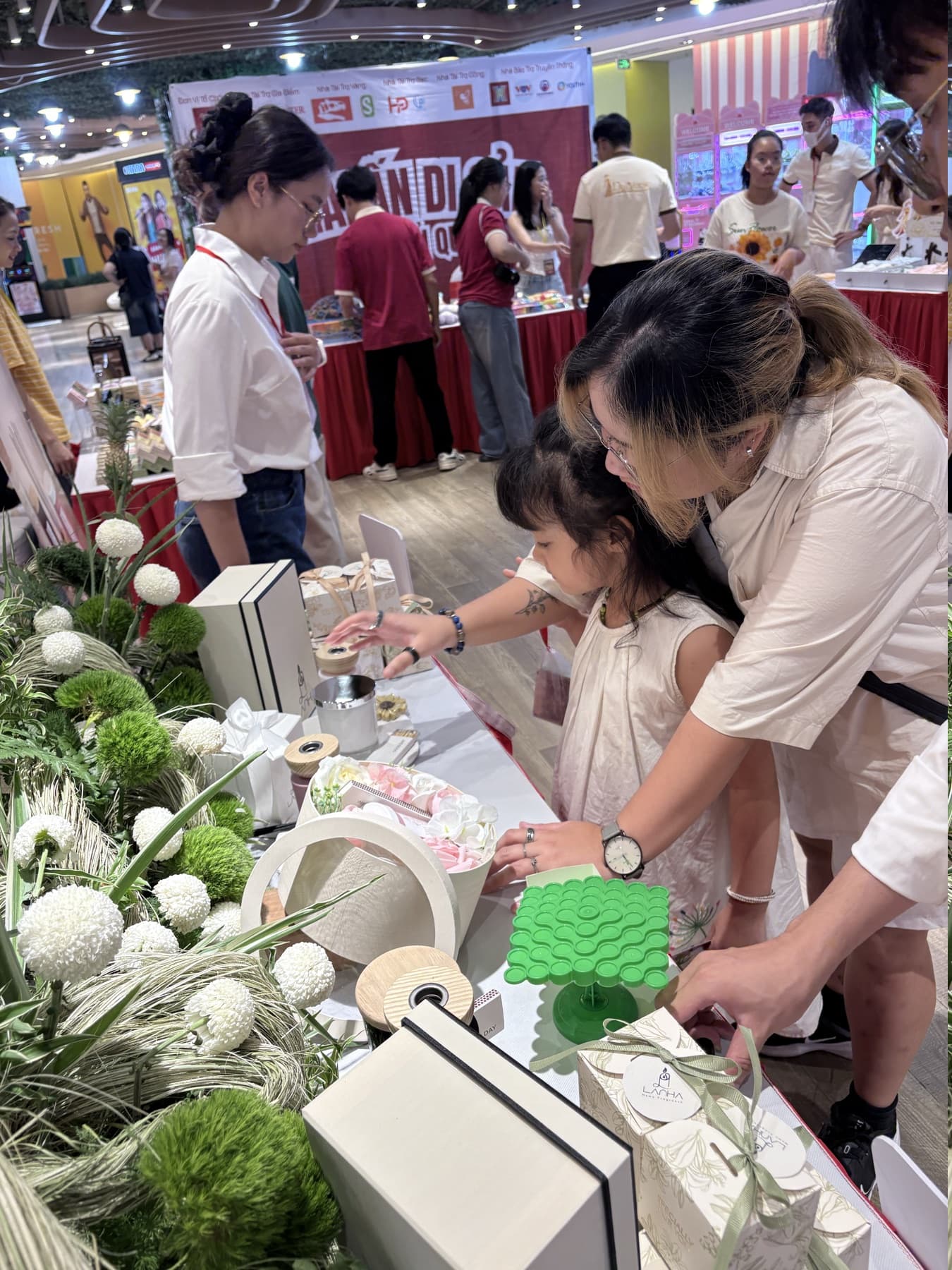 Hai mẹ con trải nghiệm sản phẩm tại gian hàng Là Nhà