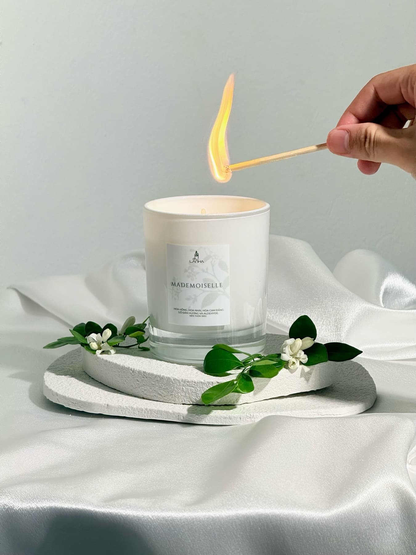 Nến thơm Mademoiselle của Là Nhà được thắp sáng